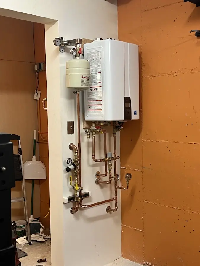 Plumbing technician inspecting water heater connections in Sellersville
